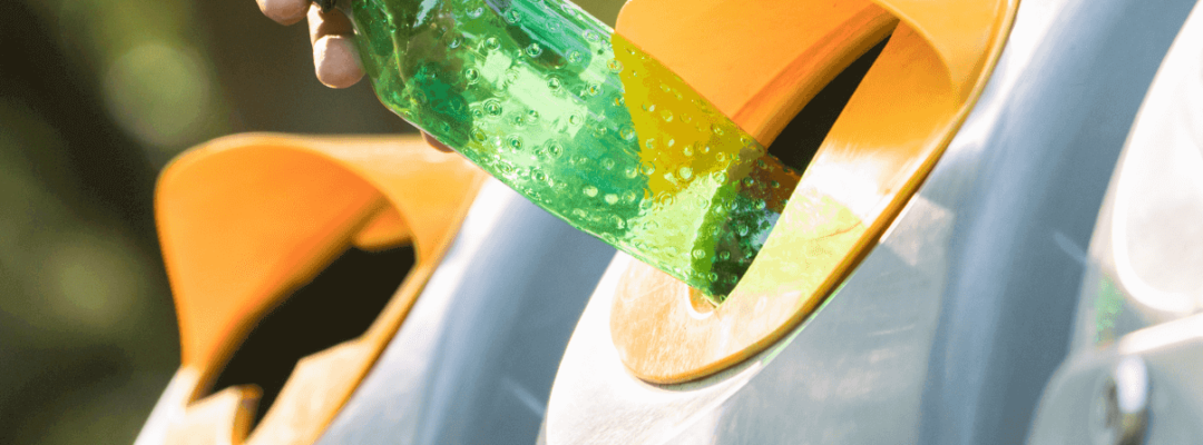 Plastic bottle being placed in a public recycling bin